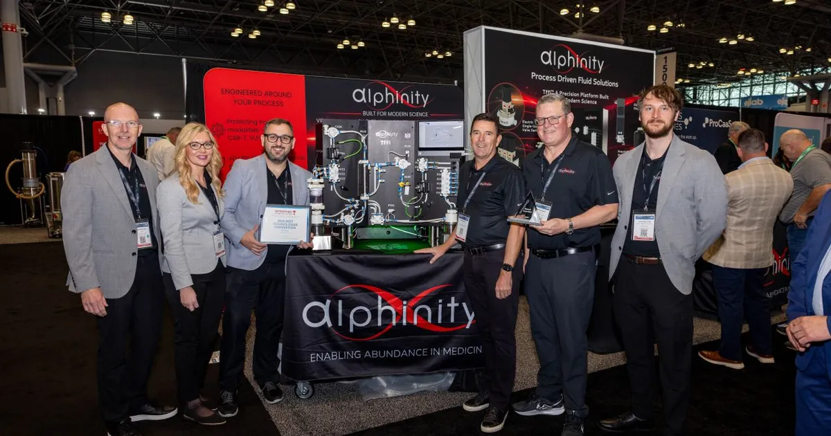 The Alphinity team at INTERPHEX 2026 holding the Best Technologies Innovation Award beside the TFFi single-use TFF system